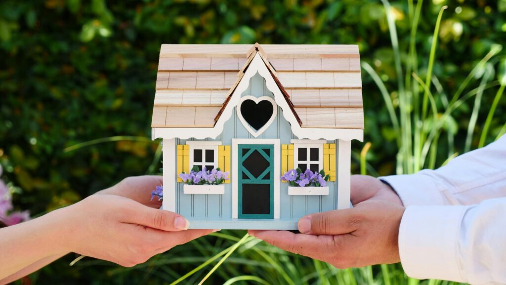 Legge di Bilancio 2026: Guida alle novità immobiliari e ai Bonus Casa Close-up of hands holding a detailed miniature house model, symbolizing goals of homeownership.